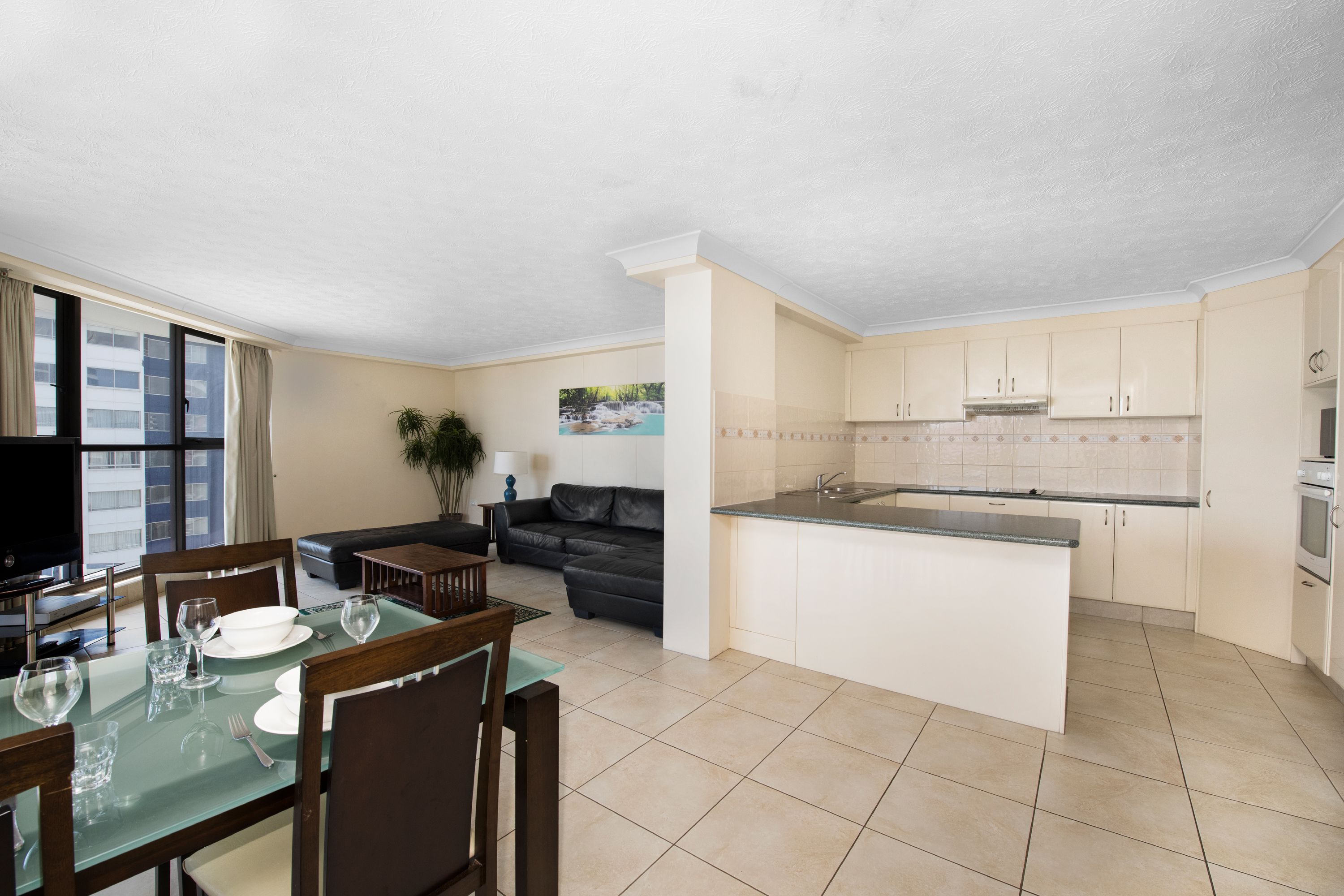 A modern apartment with a dining area, living room, and kitchen.