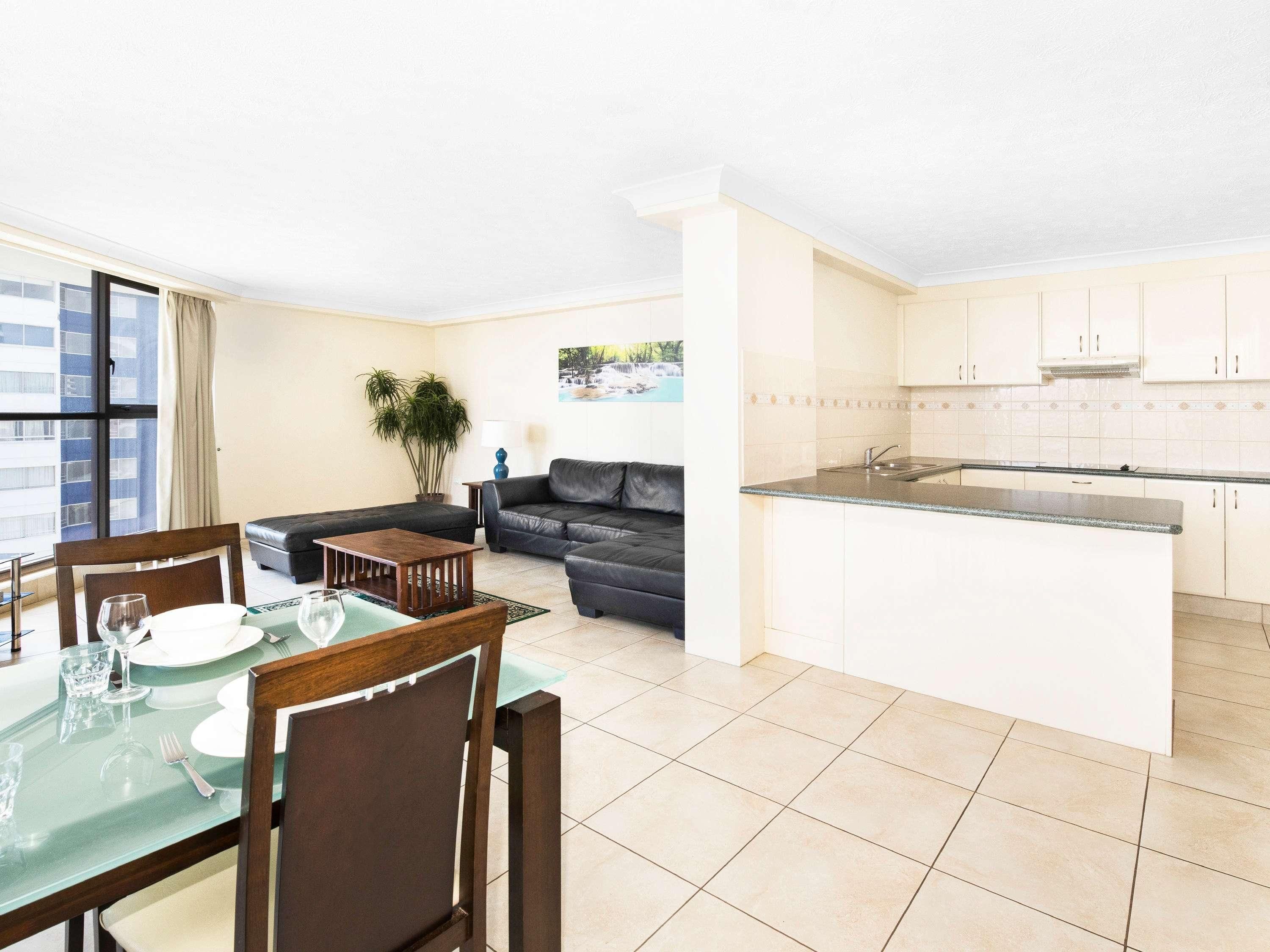 A modern apartment with a dining area, living room, and kitchen.