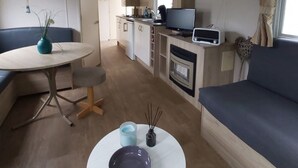 A compact living space with a dining table, a sofa, a kitchen area, and a television. - RBR 642 - Beach Resort Kamperland by Interhome (Kamperland)