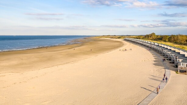 A beach with a row of beach huts along the shoreline. - RBR 642 - Beach Resort Kamperland by Interhome (Kamperland)