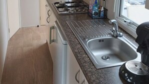 A compact kitchen with a gas stove, a sink, and a window with a view. - RBR 642 - Beach Resort Kamperland by Interhome (Kamperland)