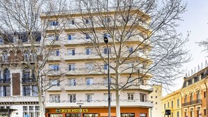 Un hotel de varios pisos con un restaurante en la planta baja y un área de estacionamiento.