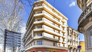 Un hotel de varios pisos con un cartel que indica diversas atracciones turísticas cercanas.