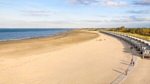 Ein Strand mit einer Reihe von Strandkörben entlang der Küste.