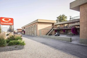 A building with a sign reading 'EconoLodge,' a paved walkway, and a motorbike parked outside. - Econo Lodge Vernon Area (Vernon)