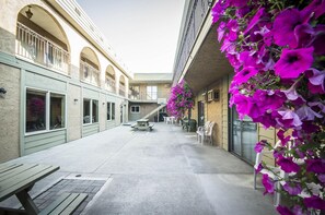A courtyard with outdoor seating, a basketball hoop, and a staircase. - Econo Lodge Vernon Area (Vernon)