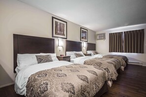 A hotel room with two beds, nightstands, wall-mounted lamps, framed pictures, and a window with curtains. - Econo Lodge Vernon Area (Vernon)