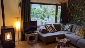 Uma sala de estar aconchegante com lareira, televisão, sofá e mesa de centro.