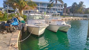 Two boats docked at a marina with a building in the background.