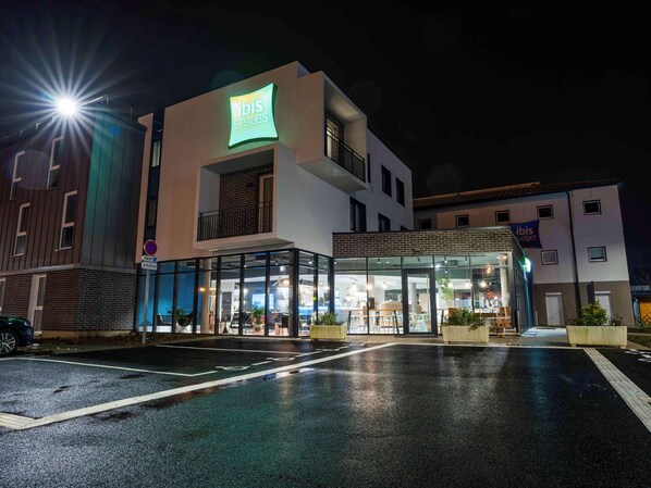 Ein modernes Hotel mit Glasfassade, einem gut sichtbaren 'ibis Styles'-Schild und einem zugänglichen Eingang.