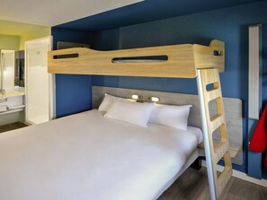 A bunk bed with a wooden ladder, a bedside table, and a mirror.