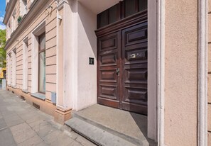 Ein Gebäude mit einer großen Holztür, einem kleinen Fenster und einem Klingel.