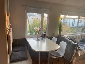A compact living space with a dining table, two chairs, a bench, and a sofa. - RBR 546 - Beach Resort Kamperland by Interhome (Kamperland)