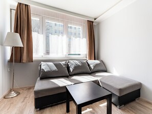 Ein modernes Wohnzimmer mit einer Couch, einem Couchtisch und einer Stehlampe.