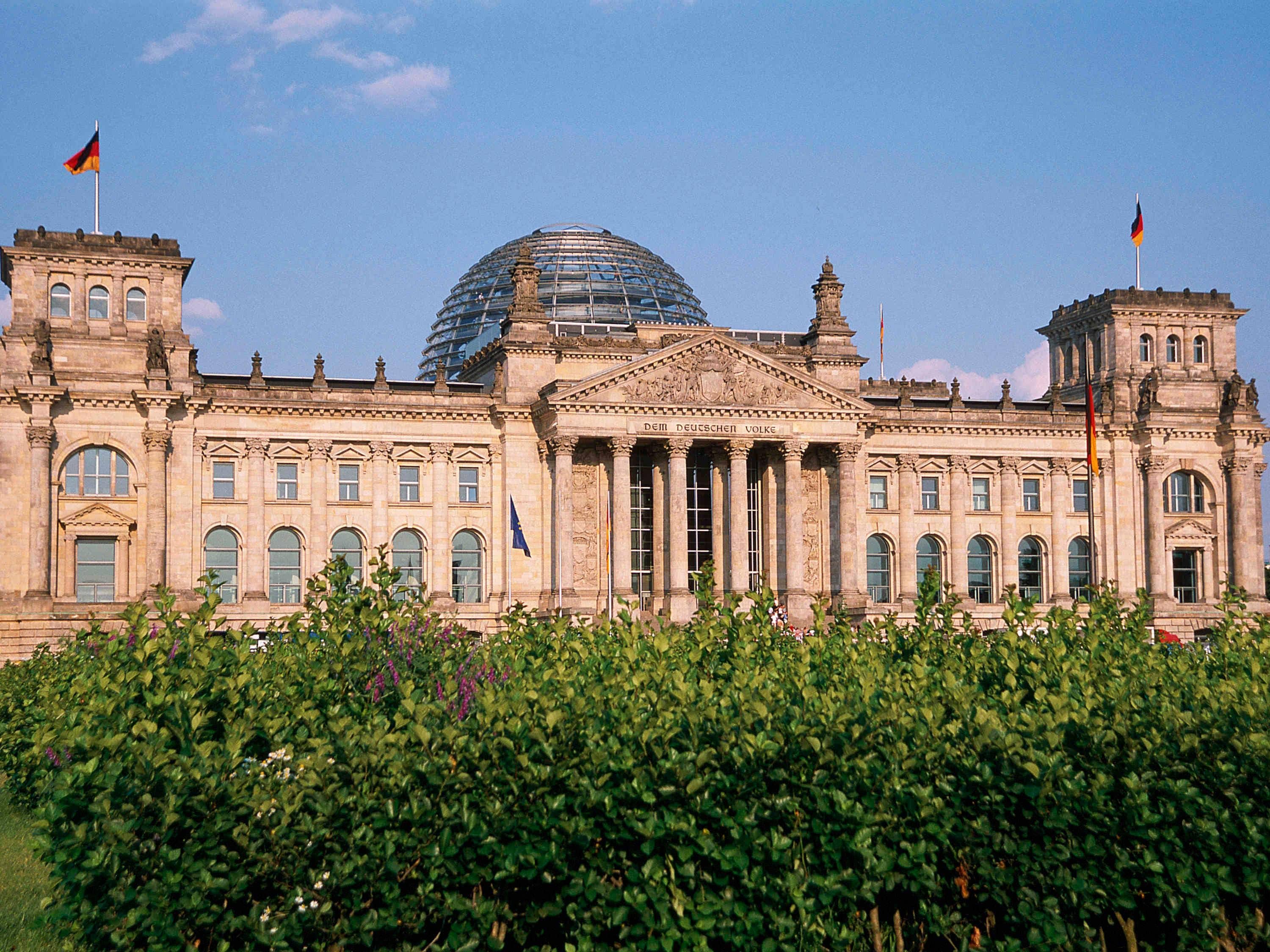 A historic building with classical architecture, featuring a central dome and symmetrical wings.