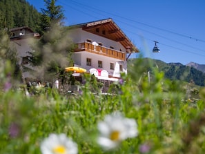 Ein Hotel mit Balkon, Bergblick und einem Schild für einen Laden.