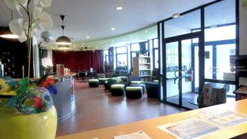 Eine moderne Lobby mit Empfangstresen, Sitzgelegenheiten und großen Fenstern.