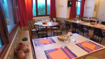 Un restaurant doté de nombreuses tables, chacune étant mise avec des couverts, des assiettes et des verres.
