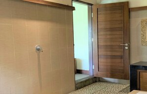 Een kamer met een schuifdeur, een klein trapje naar een deur en een betegelde vloer.