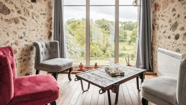 A room with a large window, a wooden table, and two chairs. - Gorgeous home in Sevremont with WiFi (Sevremont)