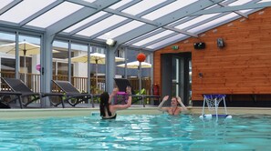An indoor swimming pool with a glass ceiling, wooden walls, and a basketball hoop. - Vvf Villages Saint-cast-le-guildo (Saint-Cast-le-Guildo)