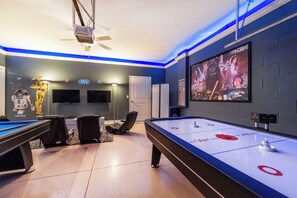 Quarto com mesa de bilhar, mesa de jogo de sinuca e decoração temática de Star Wars.