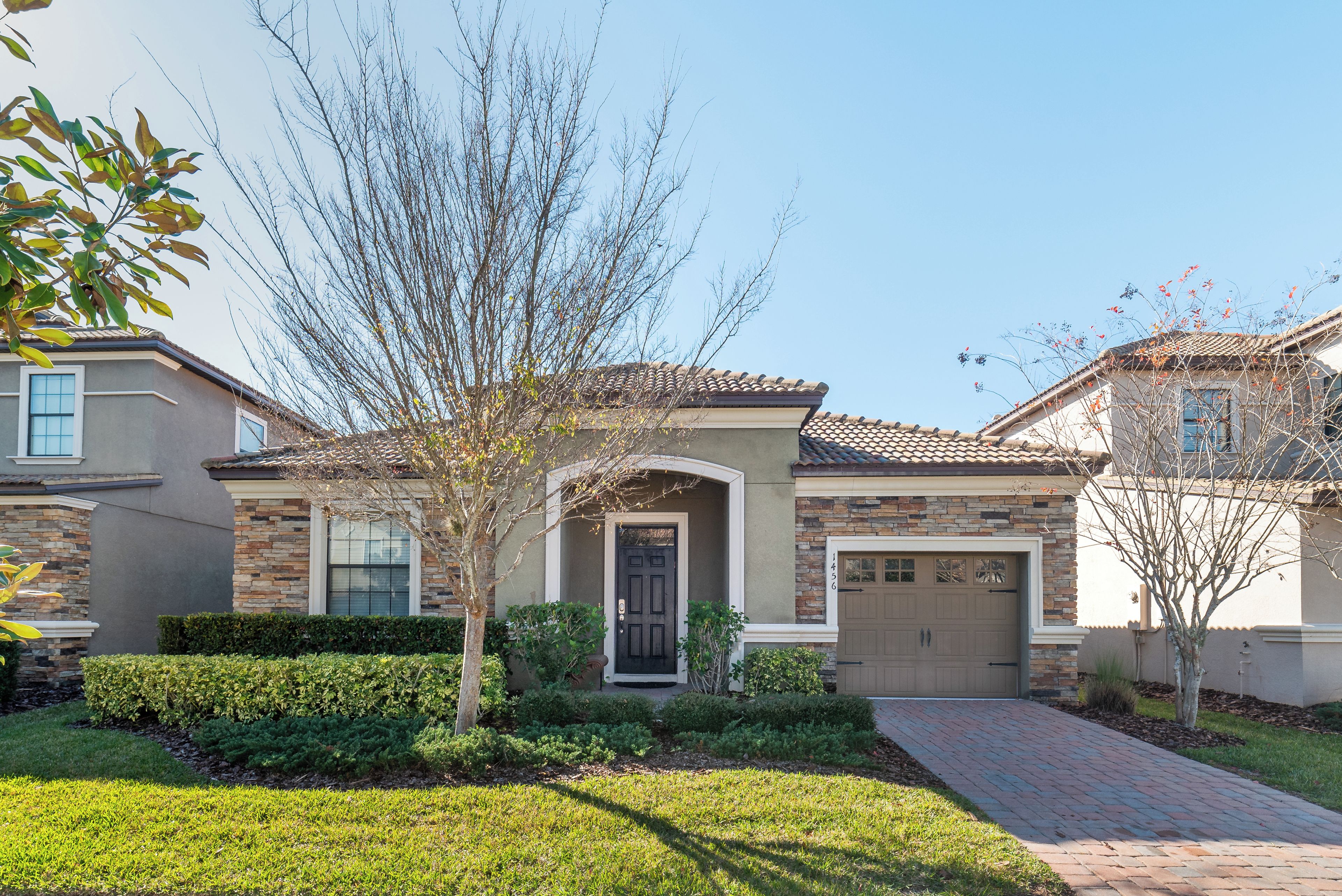 A residential house with a stone facade, a front door, and a garage.