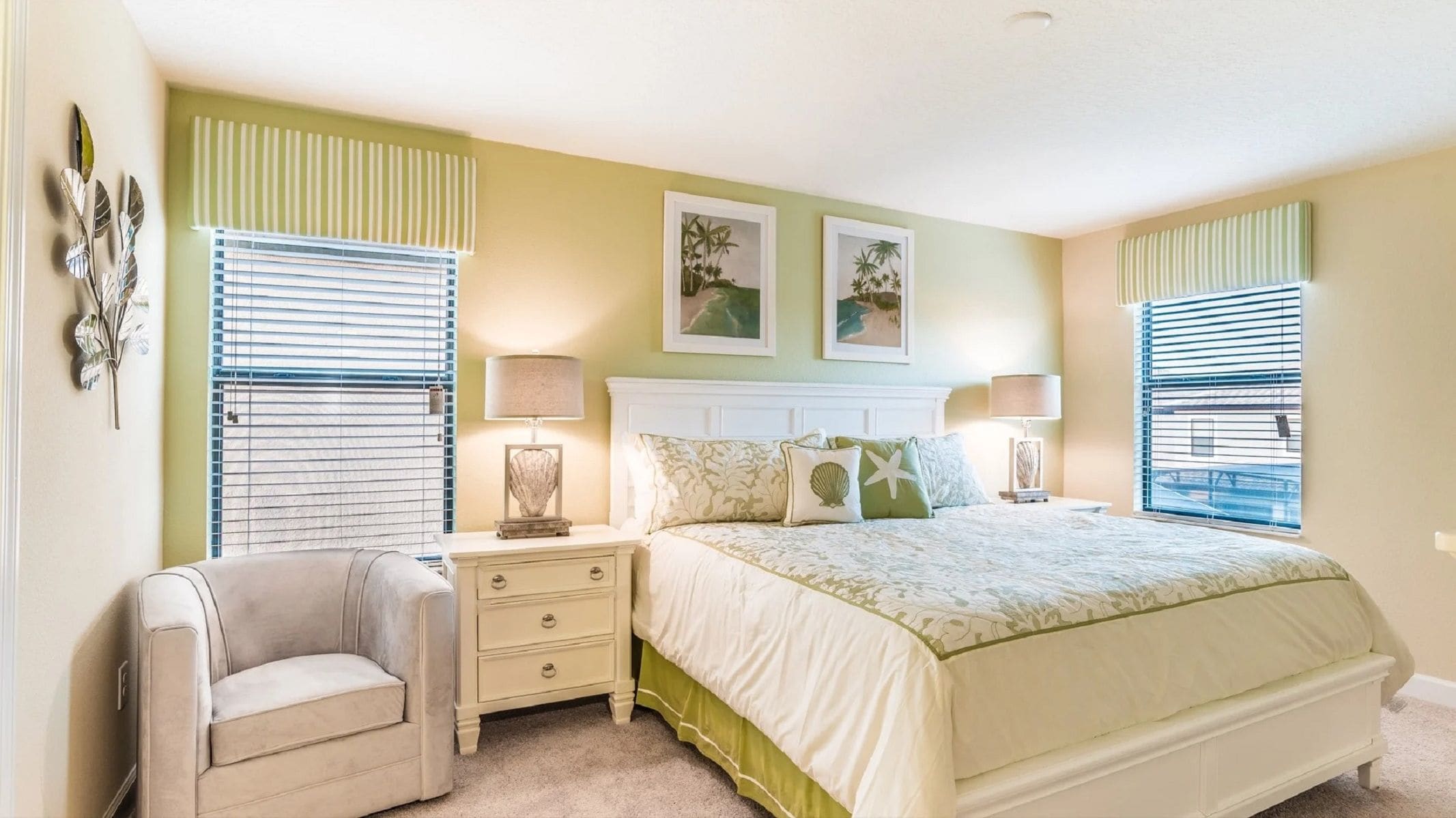 A bedroom with a bed, two bedside tables, a chair, and a window with blinds.