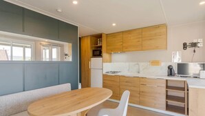 Une cuisine moderne avec des meubles en bois, un four à micro-ondes encastré et une cuisinière à gaz.