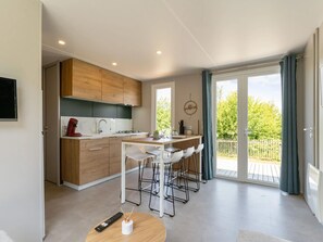 Una cocina moderna con armarios de madera, una isla central y taburetes de bar.