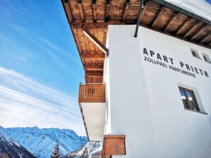 A building with a wooden balcony and a sign that reads 'APART PRIETH ZOLLFREI PARFUMERIE'. - Apart Prieth Samnaun, (Samnaun-Ravaisch) by Interhome (Samnaun)