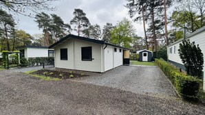 Een laag, enkelvoudig gebouw met een grindpad en een kleine tuin.