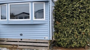 Een gelijkvloers huis met een zadeldak, een raam aan de voorkant en een raam aan de zijkant.