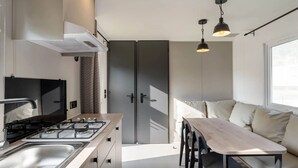 Una cucina moderna con piano cottura a gas, lavandino e zona pranzo con tavolo e sedie.