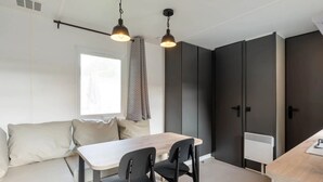 Una cucina moderna con un tavolo di legno, sedie nere e lampade a sospensione.