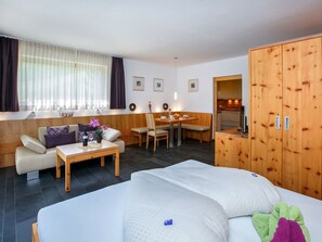 A hotel room with a bed, a sofa, a dining table, and a kitchenette. - Apart Lischana, (Samnaun-Laret) by Interhome (Samnaun)
