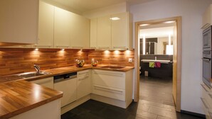 Una cucina moderna con piani in legno, mobili bianchi e lavastoviglie.