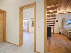 A spacious room with a wooden floor, a staircase, and a view of a cabin through a window. - APARTMENT BERGWALDZAUBER – Haus zur Post, (Samnaun-Compatsch) by Interhome (Samnaun)