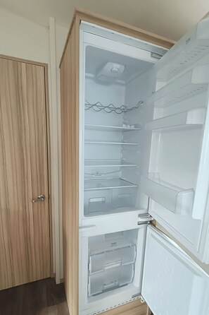 An open refrigerator with multiple shelves and a freezer compartment. - RBR 1152 - Beach Resort Kamperland by Interhome (Kamperland)