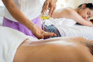 A massage therapy session with a person lying face down receiving a massage.