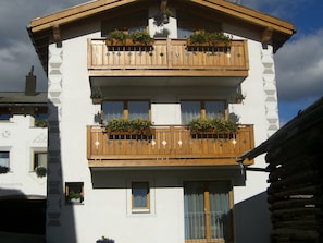 A multi-story building with balconies, each with wooden railings and flower boxes. - Haus Rupicapra, (Samnaun-Compatsch) by Interhome (Samnaun)