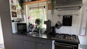 Eine moderne Küche mit grauen Schränken, einem eingebauten Backofen, einer Mikrowelle und einem Gasherd.
