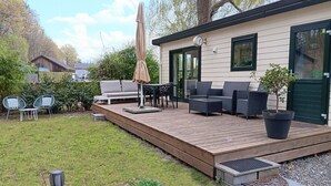 Eine Terrasse mit Gartenmöbeln, einem Blumentopf und einem kleinen Gartenbereich.