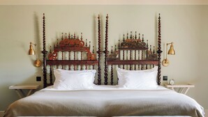 A double bed with a wooden headboard, two bedside tables, and a small clock on one table. - Quinta Nova Winery House Relais & Châteaux (Santa Maria da Feira)