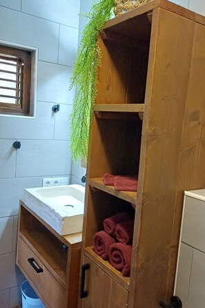 Un meuble en bois avec des étagères, une fenêtre et un évier.