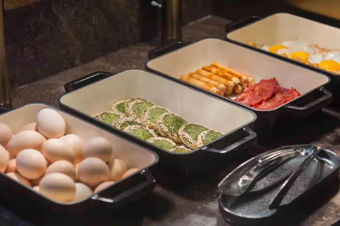 Buffet com diversos alimentos, incluindo ovos, carne e legumes.