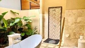 A bathroom with a freestanding bathtub, a shower enclosure, a toilet, and a sink.