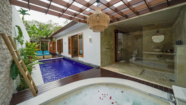 A spa area with a hot tub, a swimming pool, and a glass-enclosed shower. - Three Brothers Bungalows and Villas (Legian)
