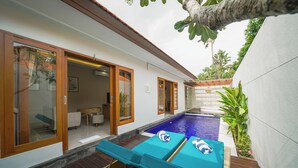 A poolside area with lounge chairs and a small pool. - Three Brothers Bungalows and Villas (Legian)