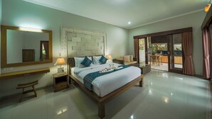 A spacious bedroom with a large bed, bedside tables, a mirror, and a view of the outdoor area.